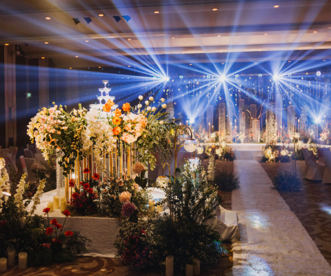 Flower arrangement for summer wedding, made of roses and green branches on a dinner table in the restaurant. , glass and plates in the restaurant outside on a windy day with film grain effect