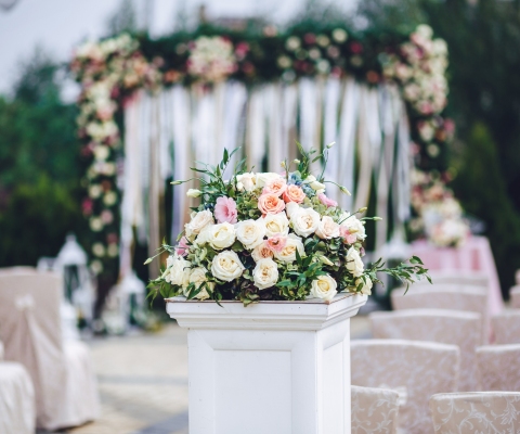 Column with rich bouquet of roses stands outside