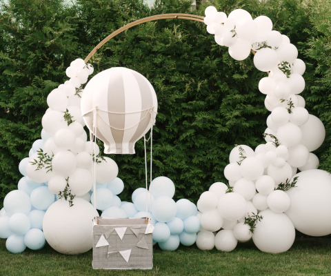 Decorations for holiday party. A lot of balloons blue and white colors. Round photo zone with balls next to a ball with a basket for a child