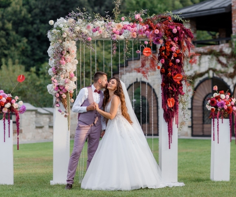 Wedding archway on the backyard and happy wedding couple outdoors before wedding ceremony